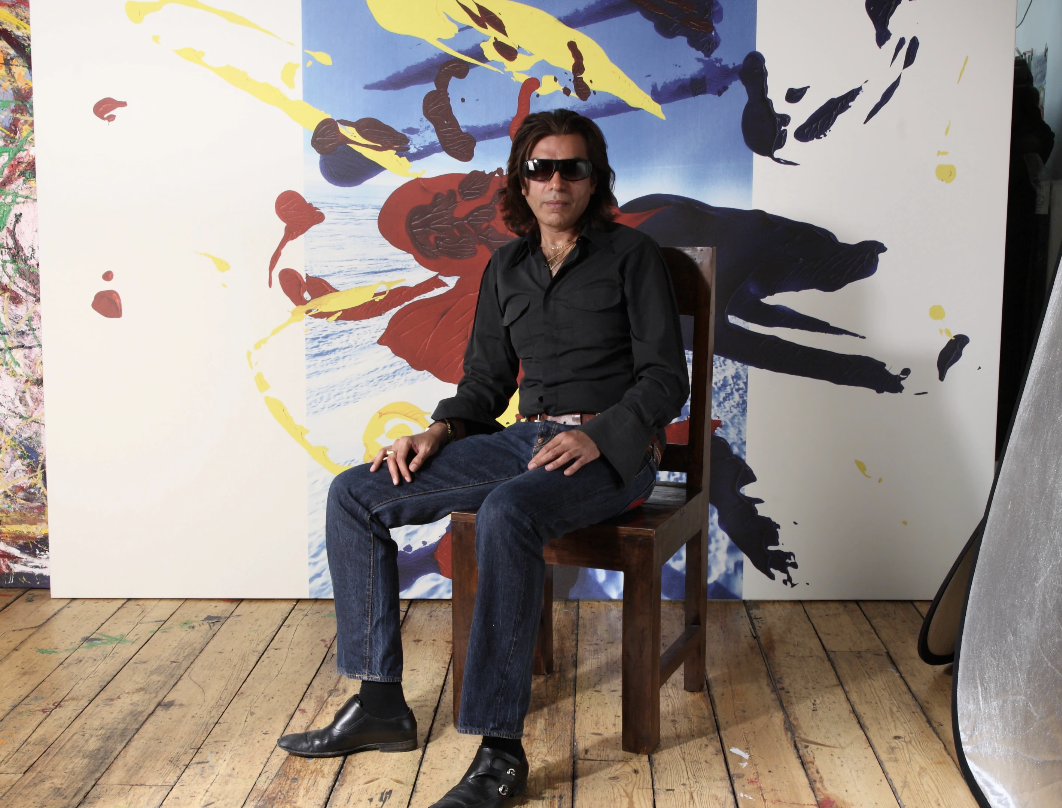 Nasser Azam, artist based in London, seated in his studio in front of a large abstract painting